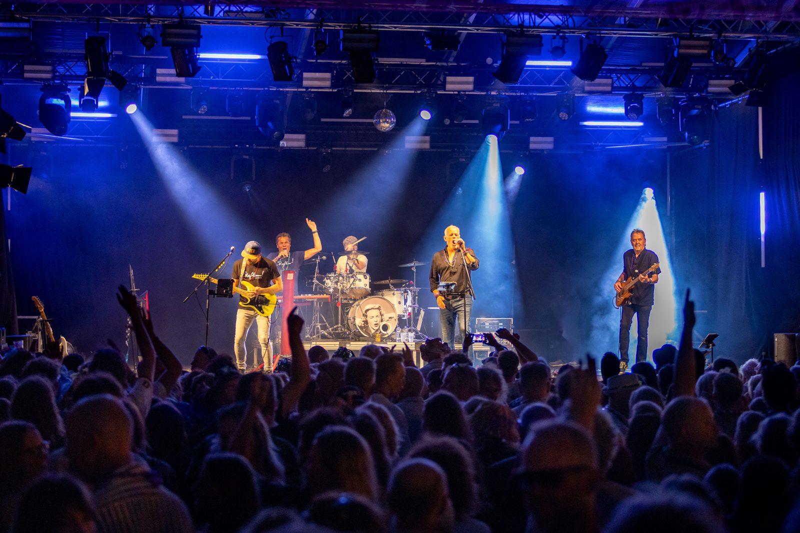 Skeftum plays Golden Earring op een groot podium in blauw licht